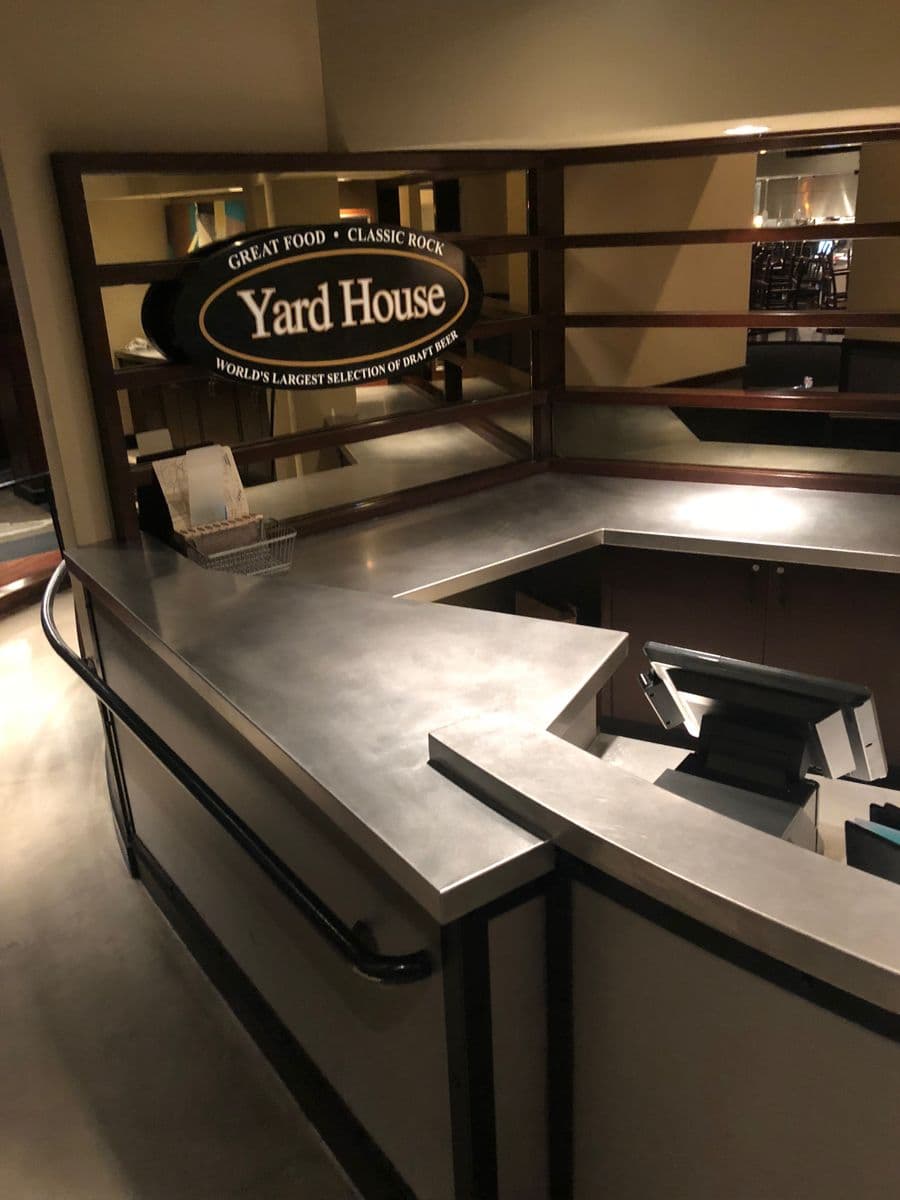 Yard House finished stainless bar top with classic-rock signage